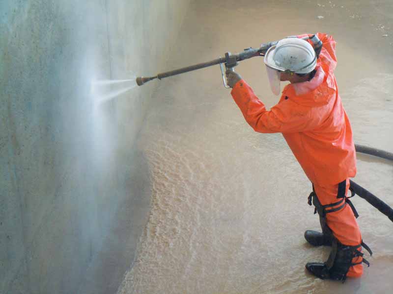 Photo courtesy Acapulco Pools Pool professional power washing a pool surface.