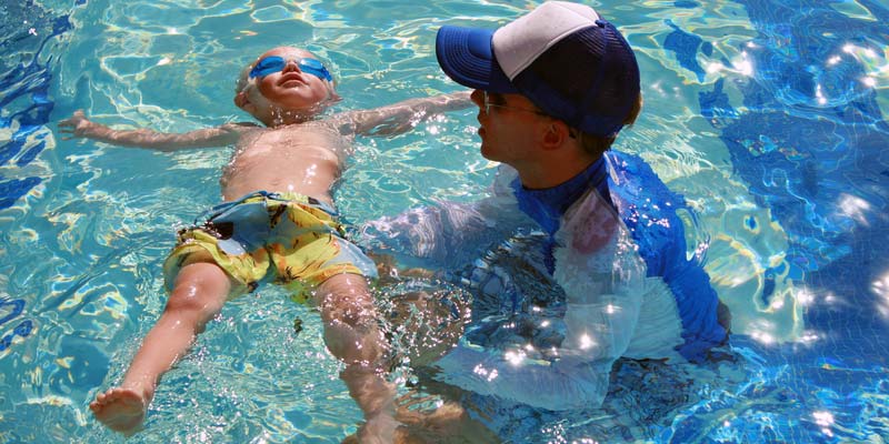 Photo ©Dreamstimephoto.com Young child learning water safety in pool with an instructor