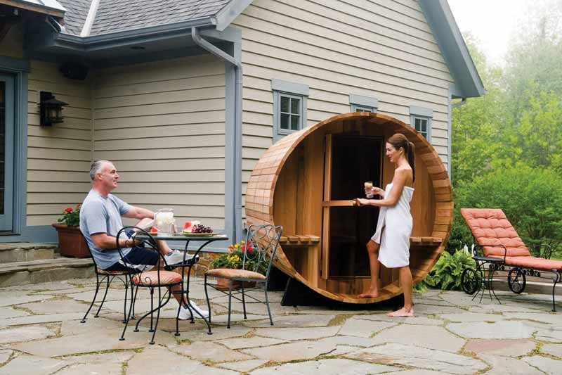 Photo courtesy Almost Heaven Saunas Woman entering a sauna in residential backyard.