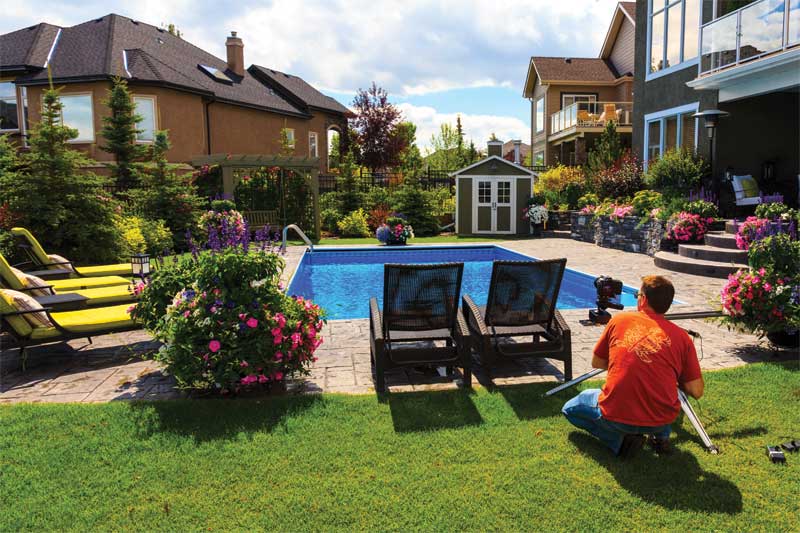 Photos courtesy The Landscape Artist Inc. Setting up a slider track for a sliding time-lapse shot of a backyard pool and landscape project.
