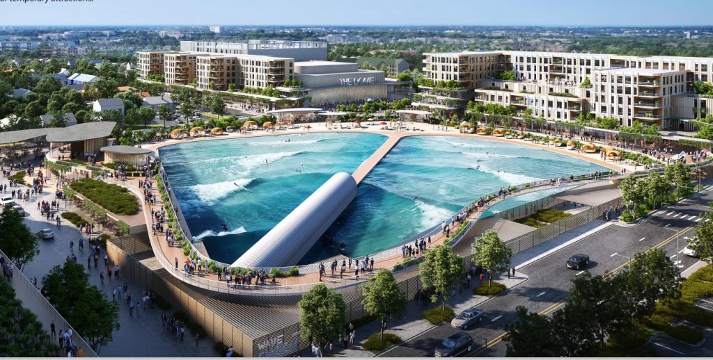 A vibrant outdoor surf park with artificial waves, surrounded by modern buildings and crowds enjoying the lively atmosphere.