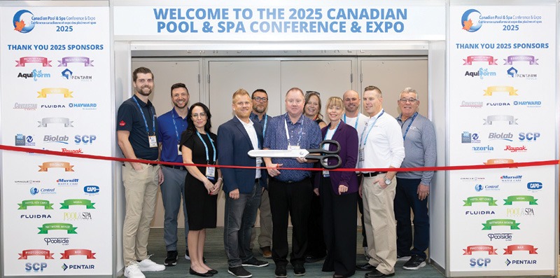 People pose with an oversized scissors before they inaugurate a pool conference.