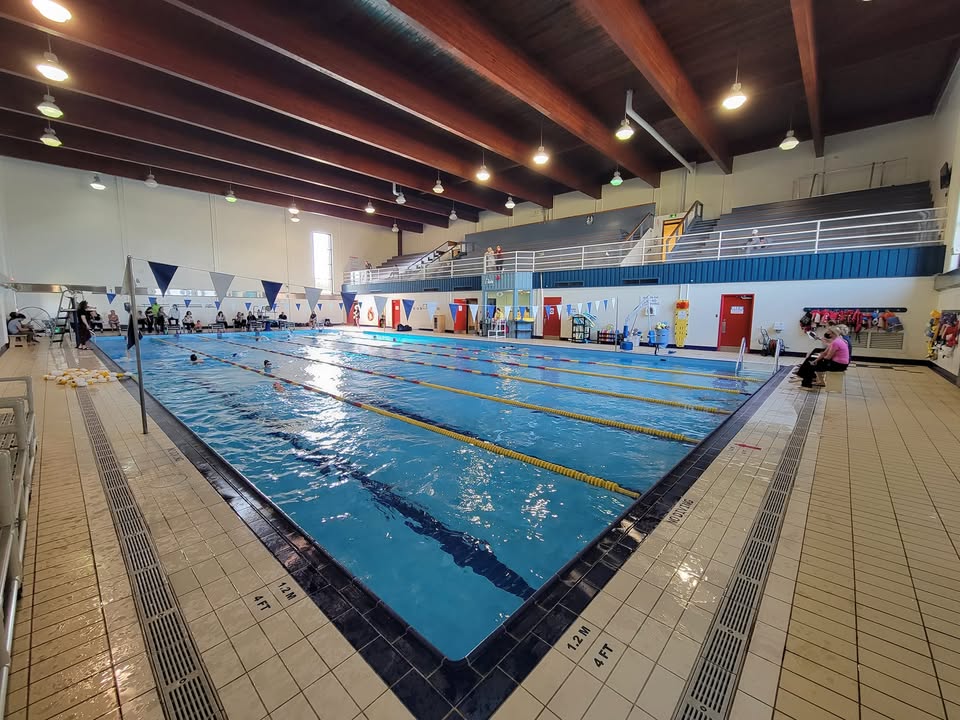 1. A spacious indoor swimming pool filled with people swimming and enjoying the water.